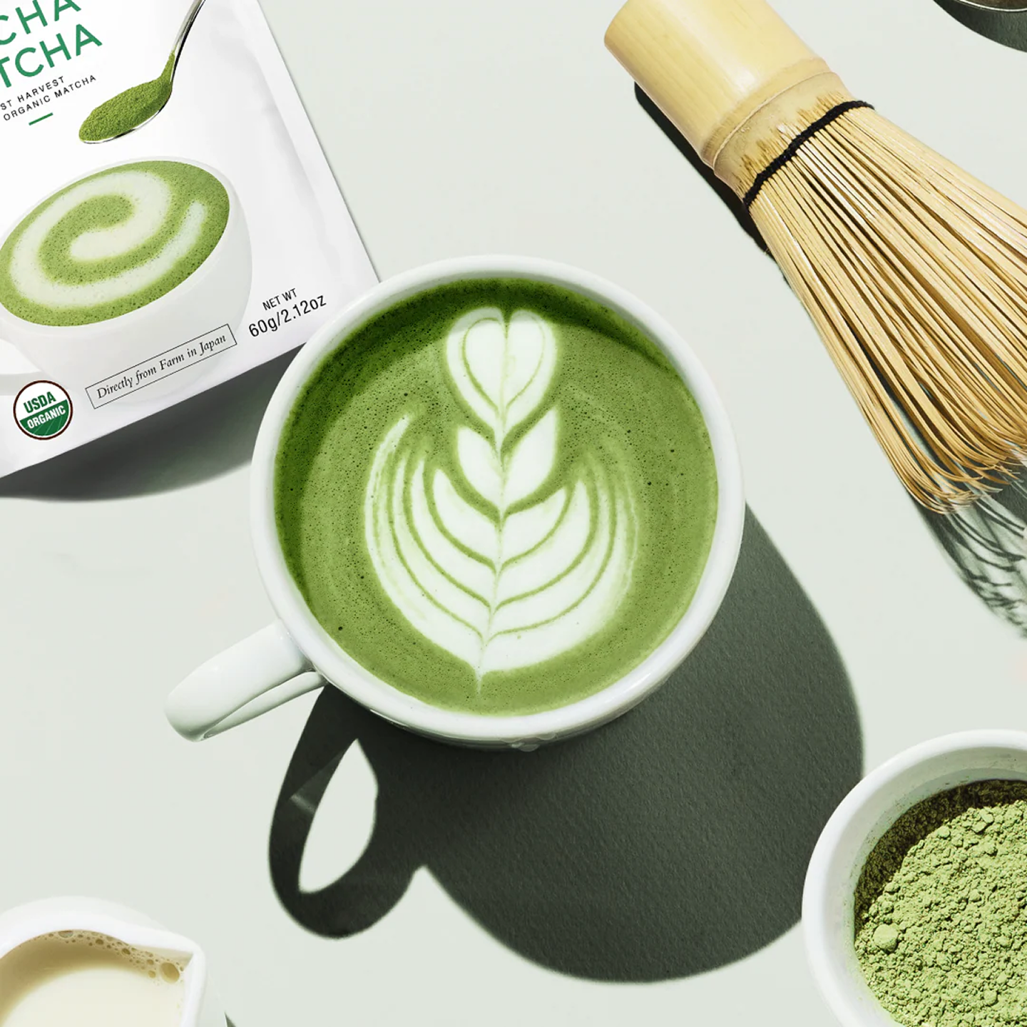 Encha matcha products with latte art and bamboo whisk